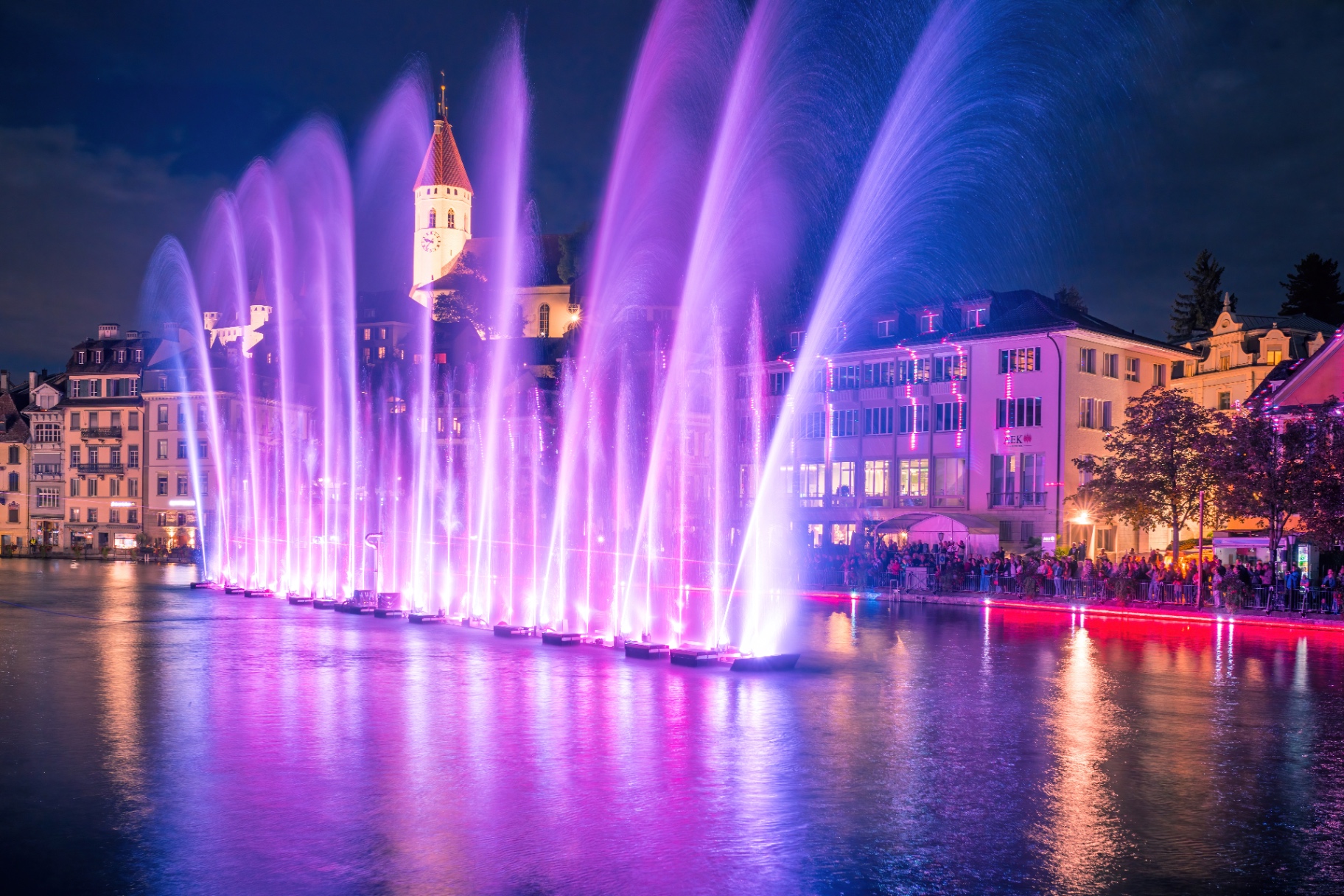 Spectacle de fontaines lumineuses aux teintes violettes